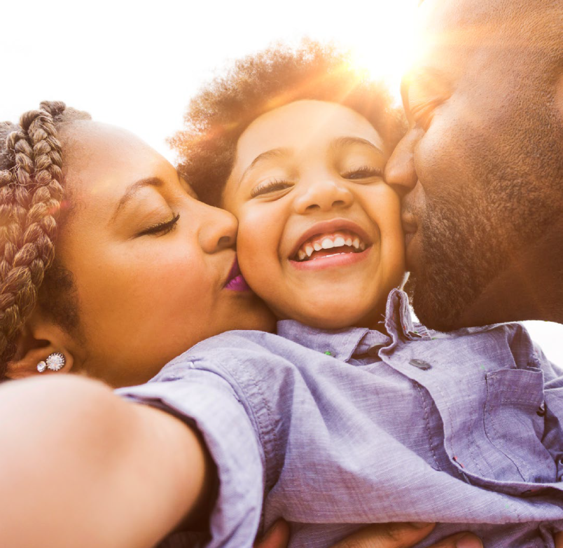 Parents kissing child 