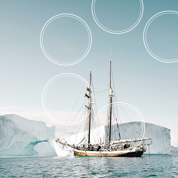 Boat at sea with icebergs in the background