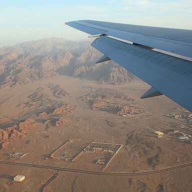 Inside view of an aeroplane wing, looking over Egyptian land.