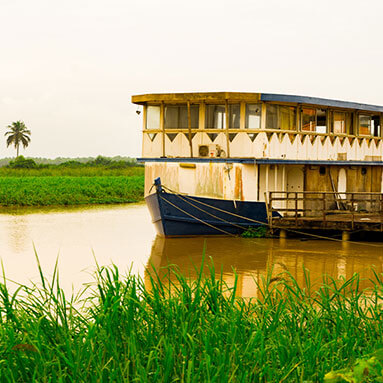 Old doube-decker ferry docked on a muddy river 