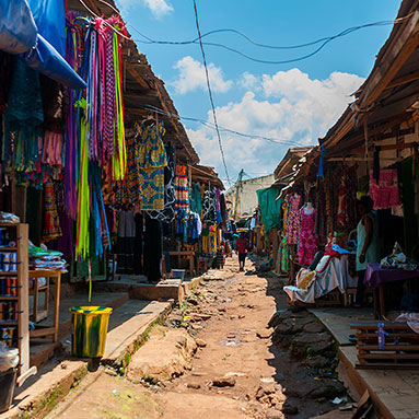 Market aisle with colourful wear being sold.