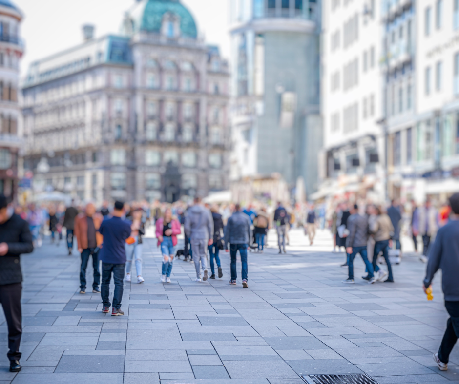 People sitting outside a restaurant with a waitress serving them