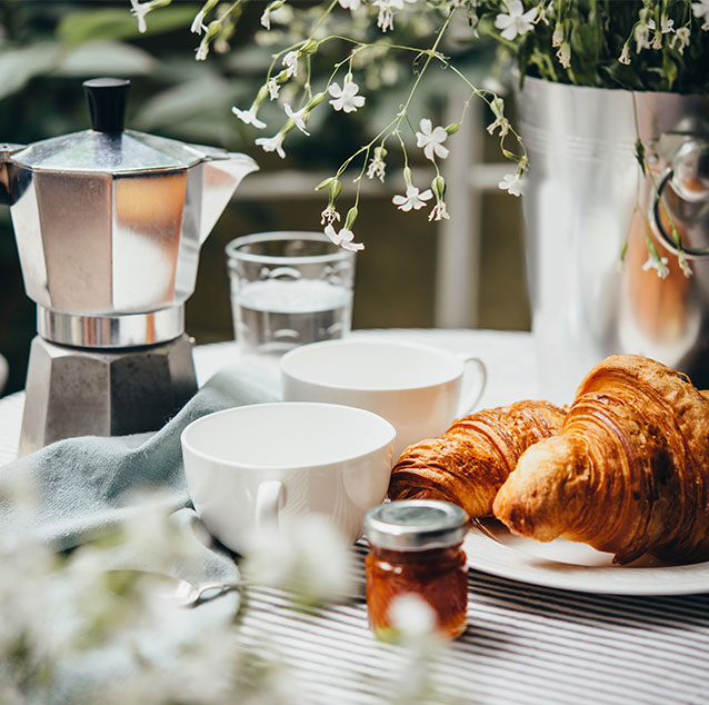 Teacups with croissants on a table.