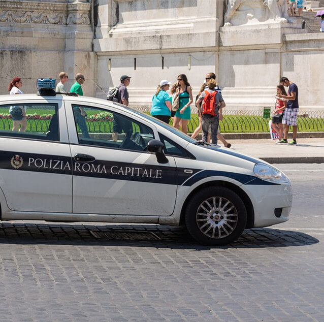 Side view of Roman police vehicle with people in the background.