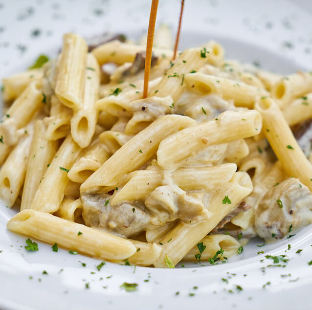 A plate of pasta penne with meat.