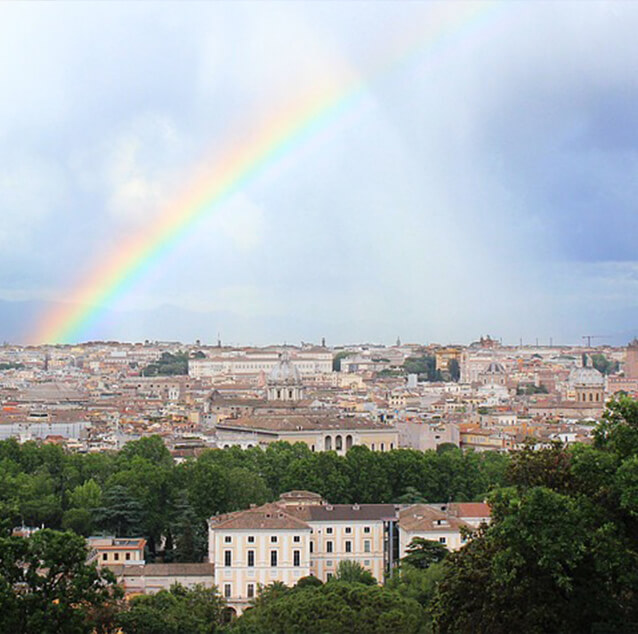 Heavy dark clouds and a rainbow over the city of Rome.