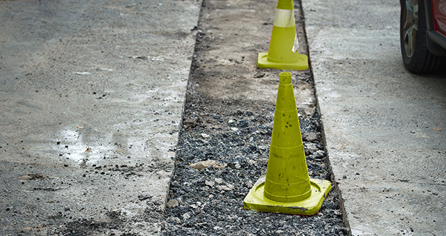 traffic cones in a large pothole in the middle of a road traffic cones in a large pothole in the middle of a road