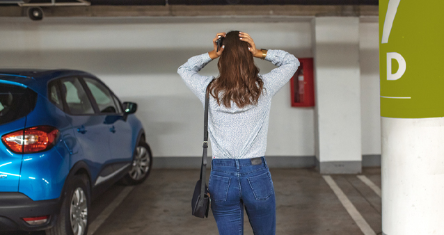 Lady with hands on head in parking garage