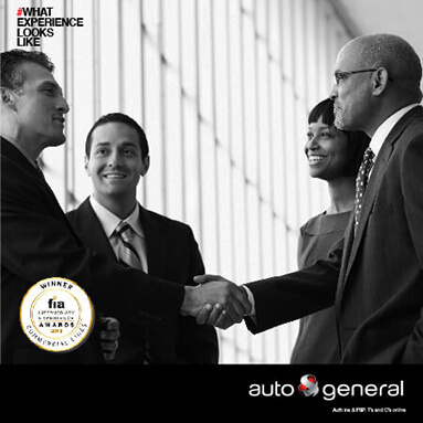 Two business men shaking hands as colleagues stand around them