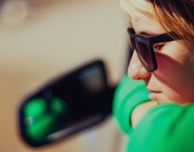 Woman leaning out of car day dreaming with sunglasses on | Unique benefits | Hippo partner
