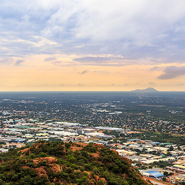 Beautiful view of Gaborone from a hillside, overlooking houses and city with pockets of green forestation.