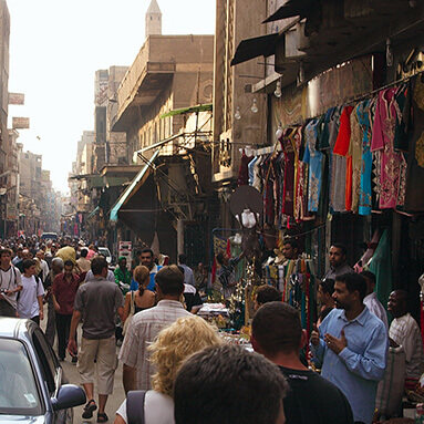 Egyptian flea market with purveyors walking past stalls and traders.