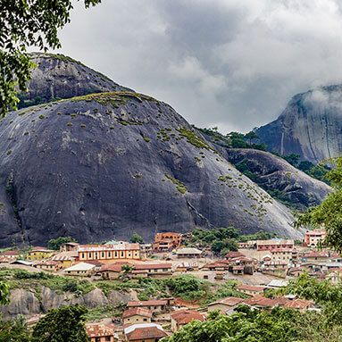 Nigerian man wearing traditional attire while walking through green forestation.  Nigerian man wearing traditional attire while walking through green forestation.